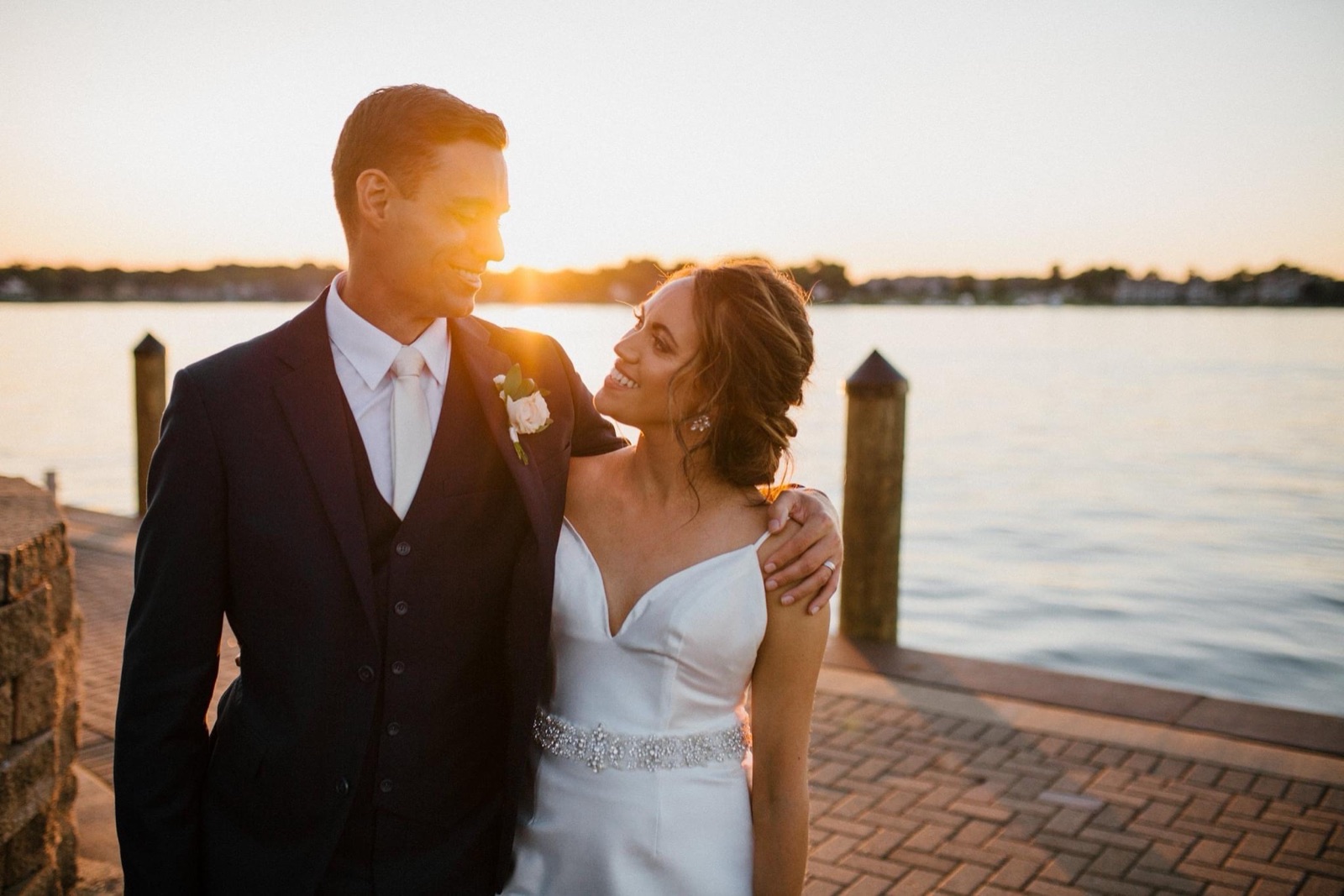 Bride and groom at sunset on a waterfront dock at their West Michigan wedding