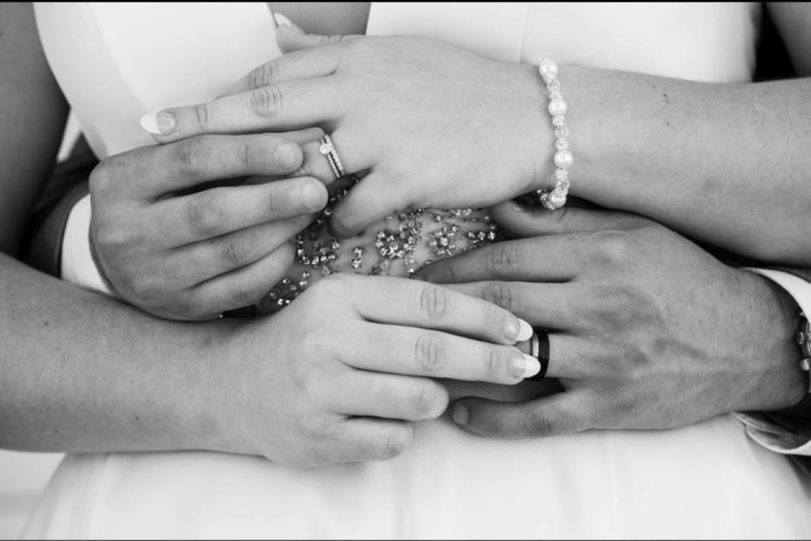 Black-and-white close-up of a bride and groom's hands with wedding rings at a Grand Rapids wedding